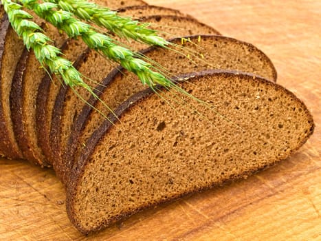 Photo of bread and grain at wooden board background