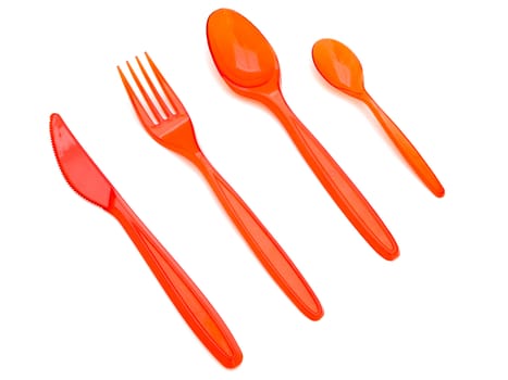 Photo of the red plastic fork knife and spoons against the white background