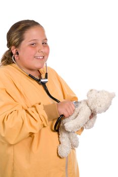 A young preteen playing with a stethoscope and checking the heart rate of her stuffed bear, isolated against a white background