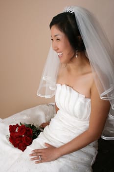 Beautiful bride wearing a traditional gown with red roses
