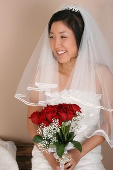 Beautiful bride wearing a traditional gown with red roses