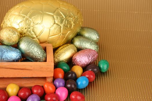 Various colors and shaped easter eggs on a gold background
