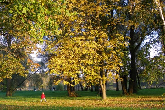Happy family (mother with small girl) in golden autumn city park