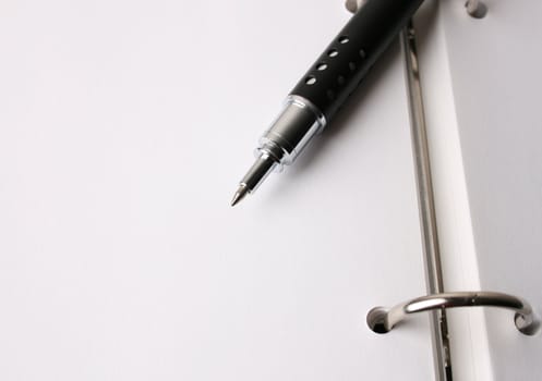 Fancy pen on a small file with white pages