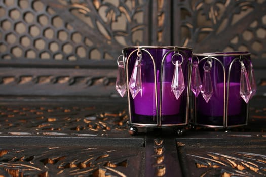Two purple crystal candle holders on a rustic background
