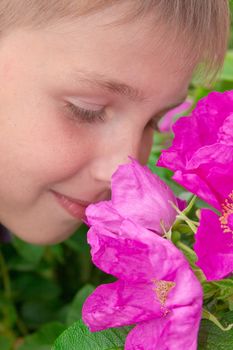 Portret of little  boy smelling  flowers outdoors