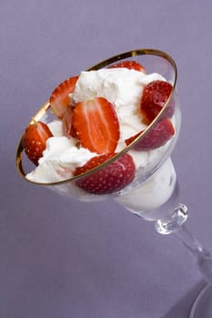 White tasty ice-cream in glass with cut strawberry