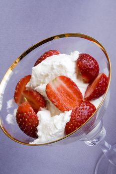 White tasty ice-cream in glass with cut strawberry