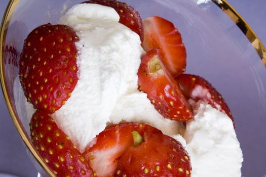 White tasty ice-cream in glass with cut strawberry