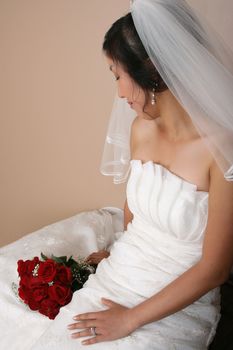 Beautiful bride wearing a traditional gown with red roses