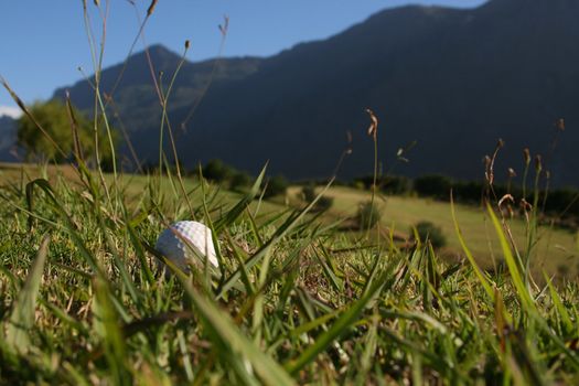 Golf Ball on a golf course with a mountain range in the background