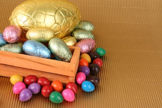 Various colors and shaped easter eggs on a gold background