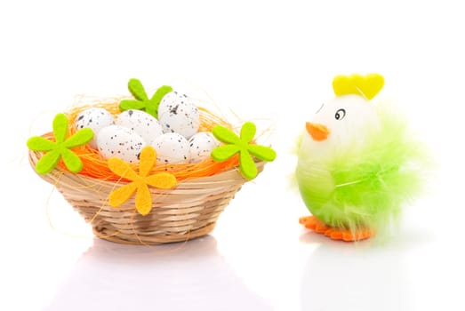 Easter eggs in basket and decorative chicken isolated on white background