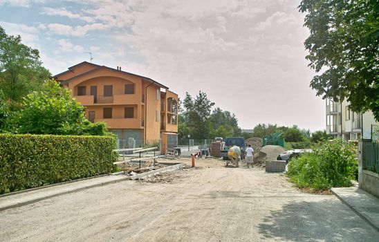 workers finishing the street and the new building at city limits