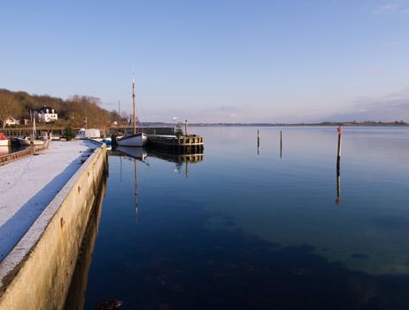 Reflection of a beautiful vintage classical wooden sail boat in a marina