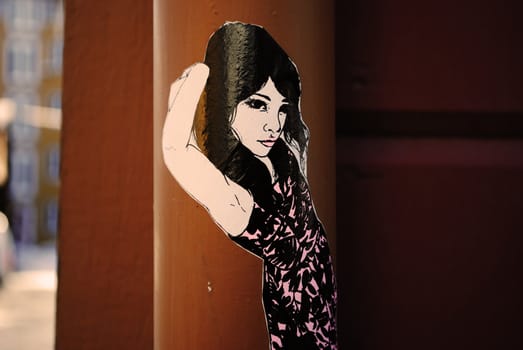 A street art sticker depicting a pretty girl.