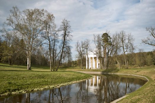Classical rotunda near river in spring park
