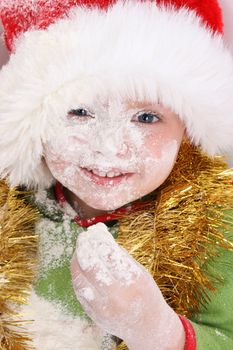 Toddler wearing a christmas hat, baking christmas cookies