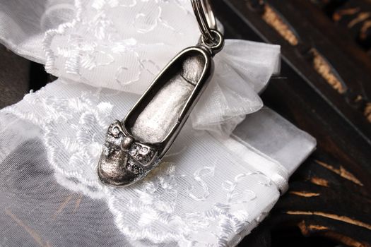 Silver Cast shoe on a keyring with a white organza bag