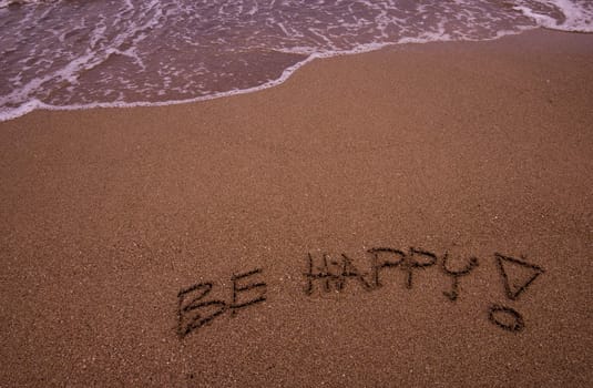 Be Happy written in sand on the beach