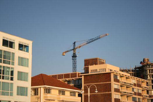 Building Crane behind other buildings with construction to the right