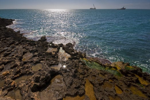 Seashore with ships on horizon