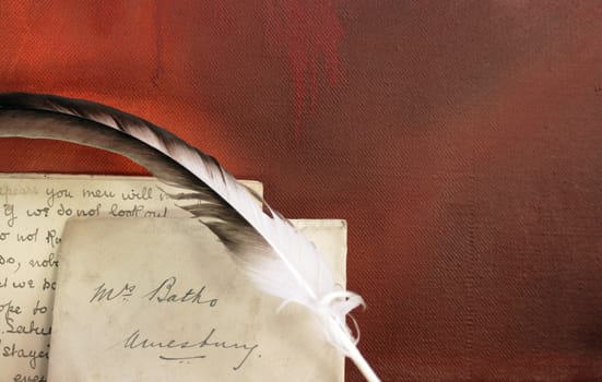 Period set up of a letter,quill pen set on top of a wooden mantle against a red grunge background. All props recreated by self as artist.
