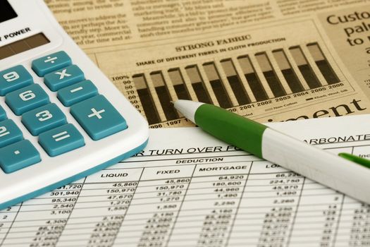 spreadsheet with pen,calculator and financial graph.
