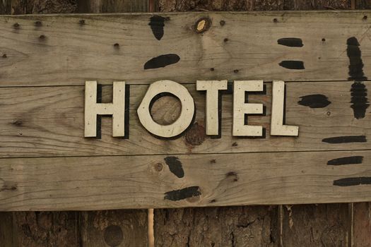 A western style hotel sign on wooden panel
