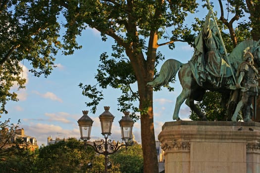 Scene opposite Notre Dame Cathedral, Paris France. Looking towards the centre of Paris. Statue in view ith street lights at dusk.