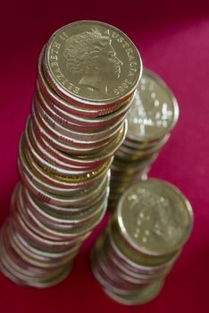 a large stack of australian dollar coins on a red background