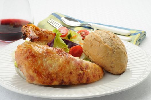 Barbecued chicken with salad and crusty roll.