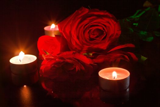 Red roses with candles on black