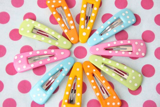 Brightly colored polka dot hair accessories on a polka dot background