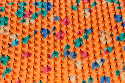 Periodic structure with bases of multicolored rubber and metal needles. Drops of water on the surface. Used in Medicine