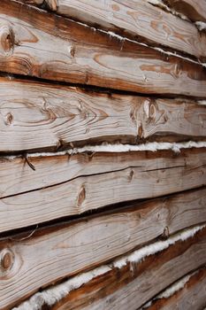 Detail of a wall of parallel wooden logs with insulation between them