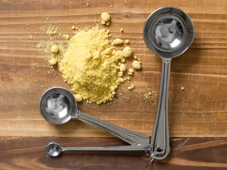 close up of mustard powder with measuring spoons