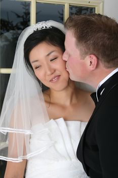 Beautiful Asian and Causian bridal couple on their wedding day