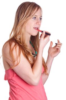 A girl is applying chapstick.  She is in a very colorful outfit.