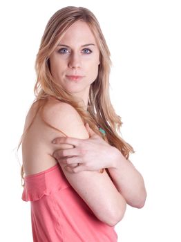 A girl in bright colorful outfit covers her arm and stares at the camera.