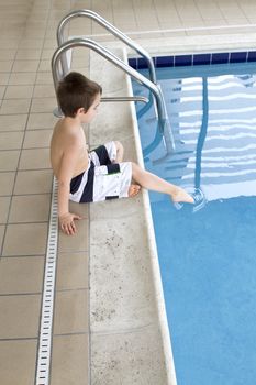 Checking out the water temperature before entering the swimming pool.