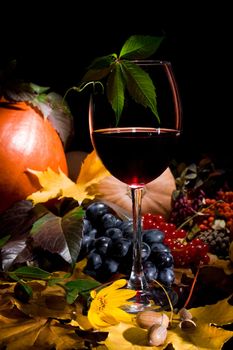 Autumn crop with red wine  isolated on black