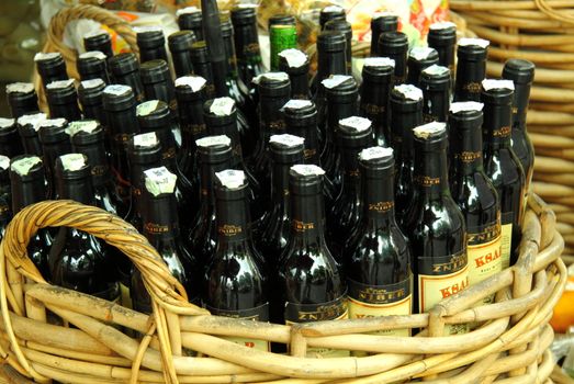 Basket full of bottles of red wine for sale in a street market in France 