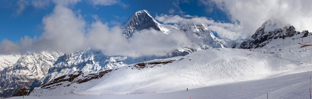 Ski slope in the background of Mount Eiger. The Eiger is a mountain in the Bernese Alps in Switzerland. Panorama.