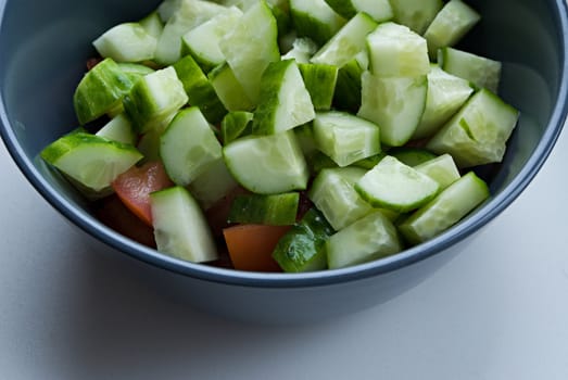 Cooking fresh salad with cucumbers and tomatoes