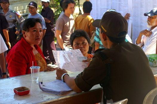 An official checking the identity cards of Indonesian voters in the Presidential election. Tuban, Bali, Indonesia.