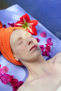 Aromatherapy on a blue board with pink flowers, natural light