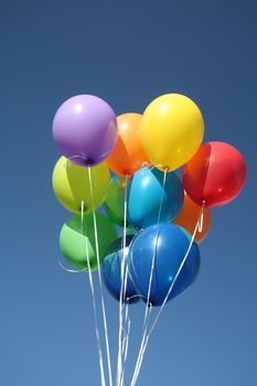 Colorful balloons dancing in a blue sky