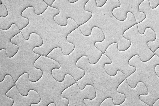 Blank grey complete cardboard jigsaw puzzle shot at an angle, great details on the pieces