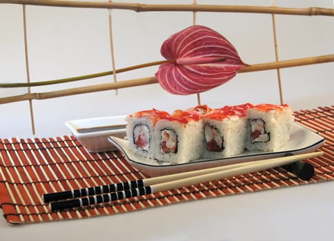 sushi and chopsticks on a background of a decorative bamboo lattice